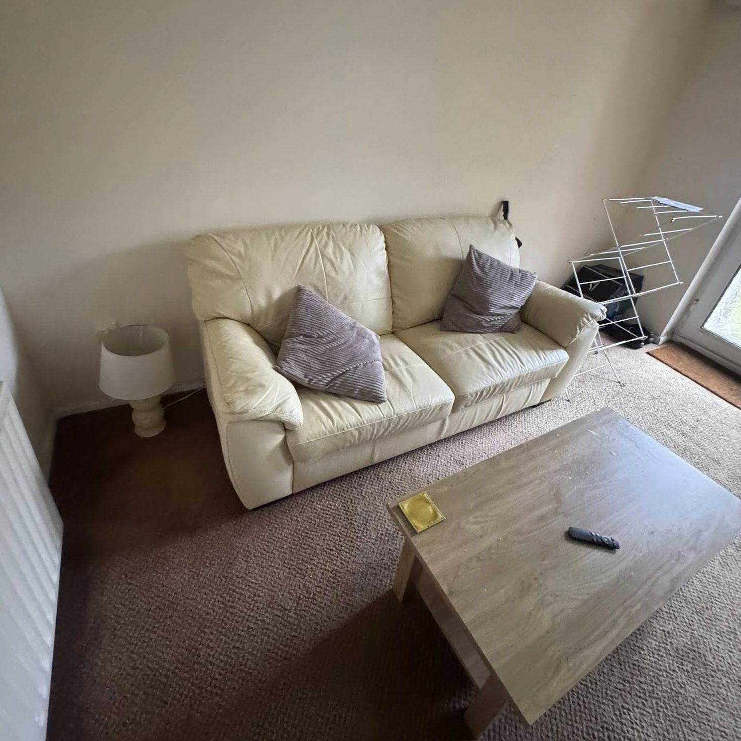 Living room heavily cluttered with furniture left behind by previous tenants
