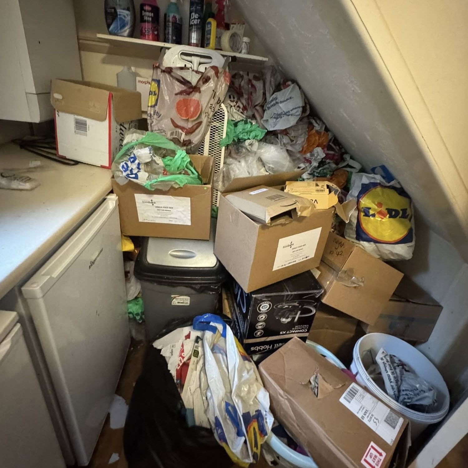Cluttered kitchen in Woodcote with abandoned appliances and rubbish on worktops