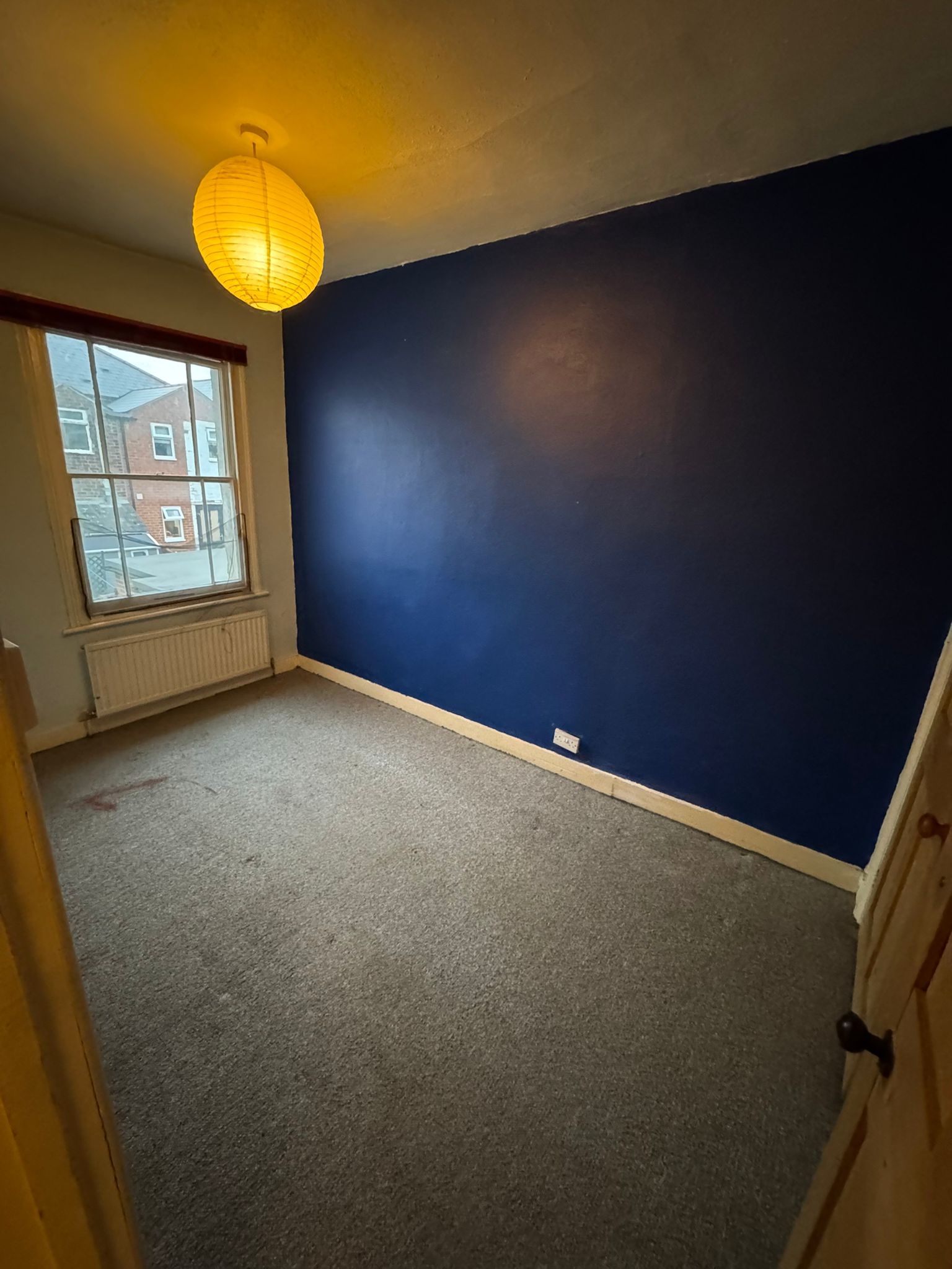 cleared bedroom with blue wall and light