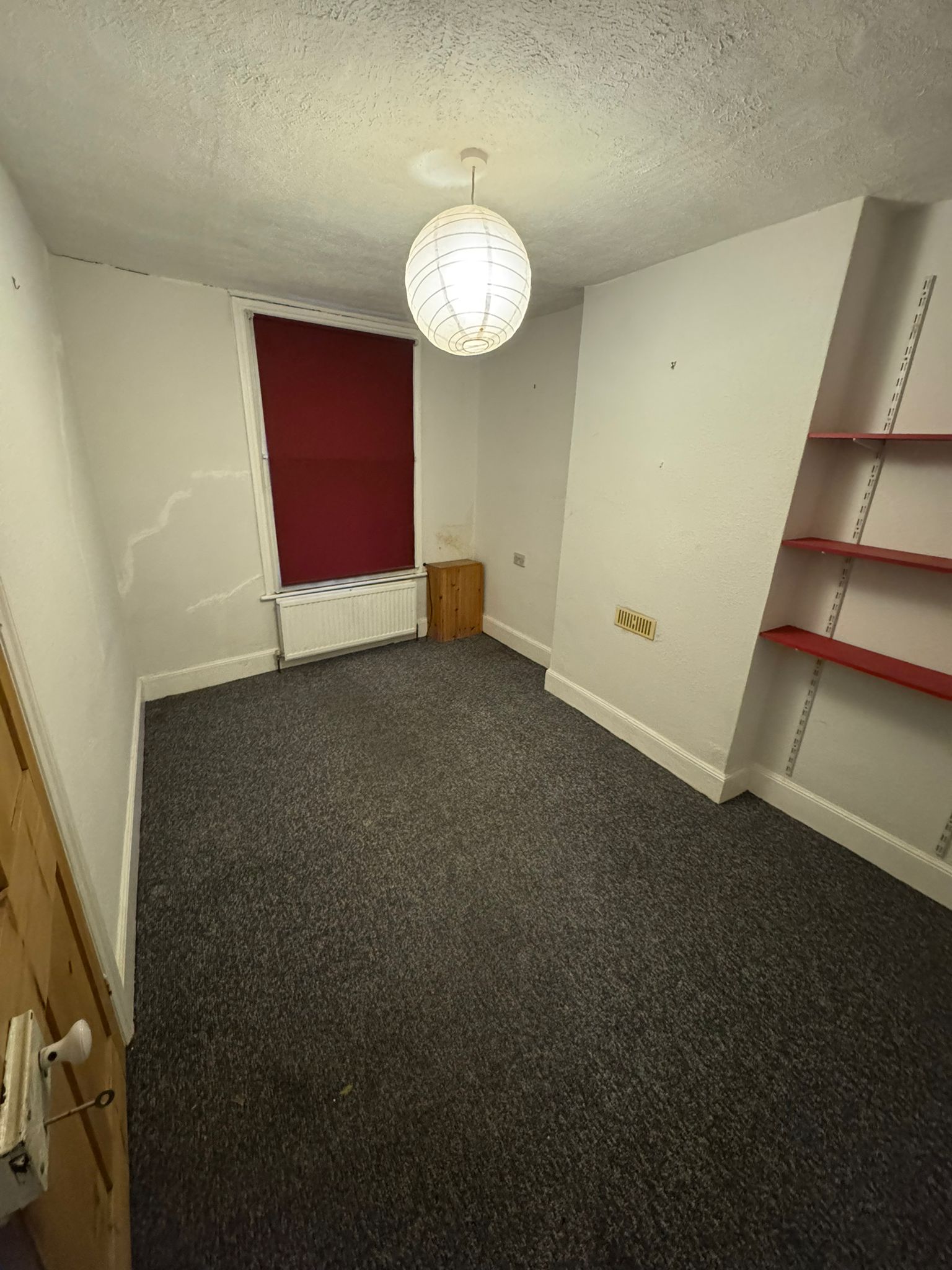 empty room with red blind and shelves