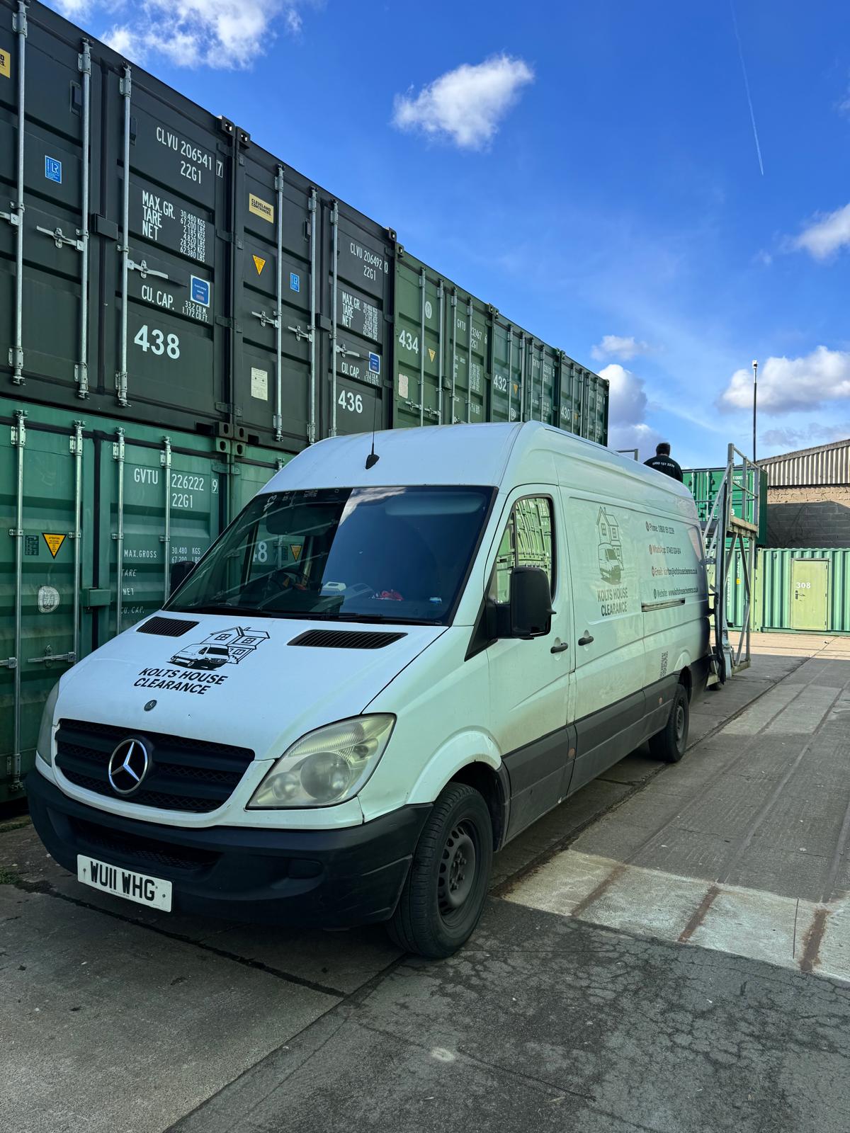 house clearance van next to shipping containers
